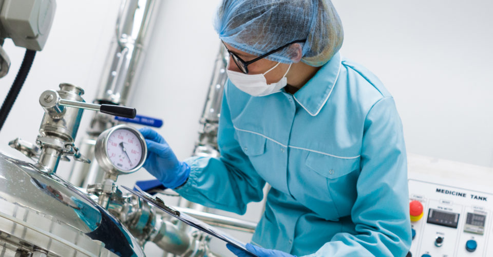 Man stood in PPE Equipment next to machine