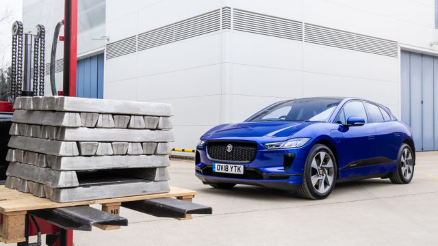 Blue Jaguar parked infront of aluminum